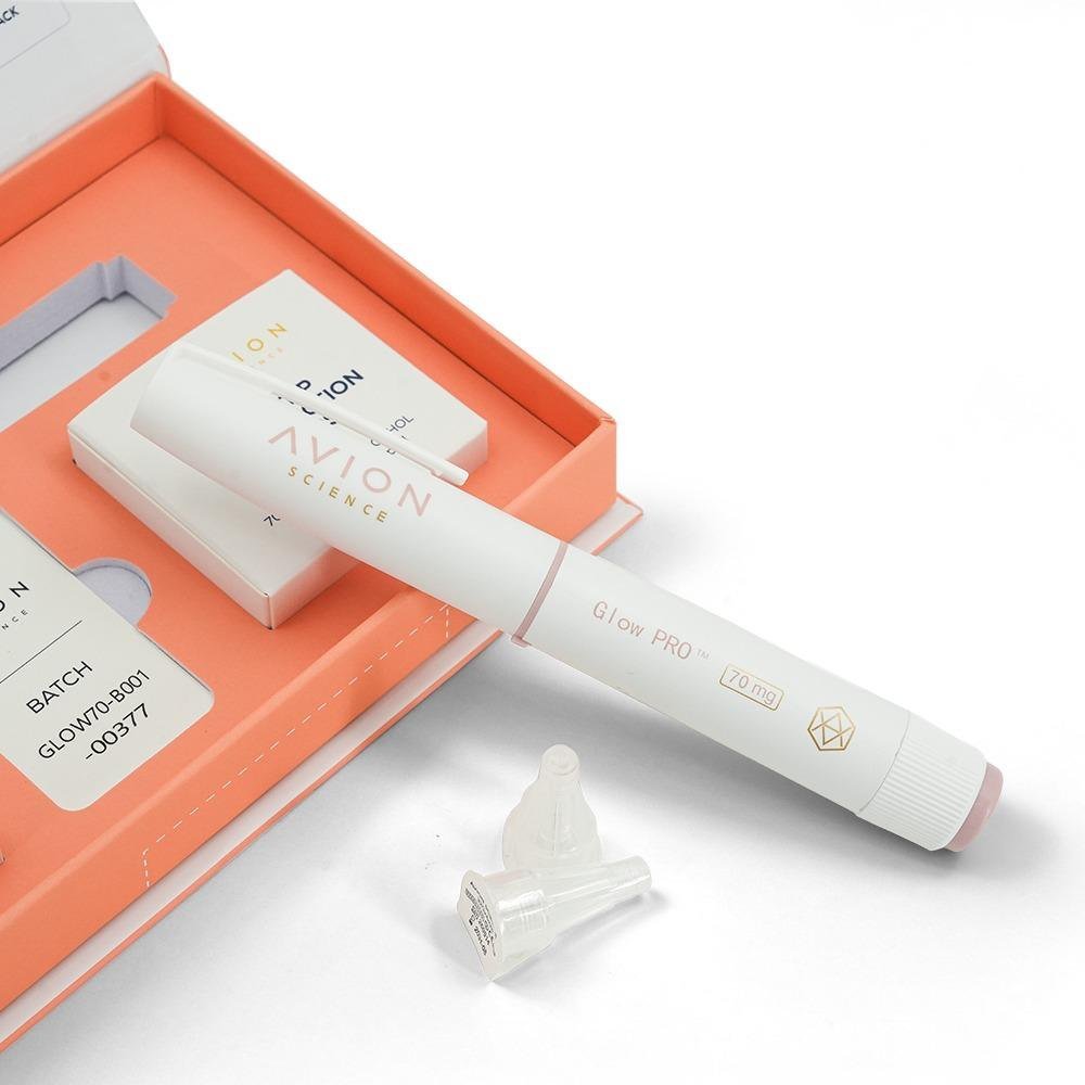 GLOW PRO pen in its coral kit tray next to its batch label